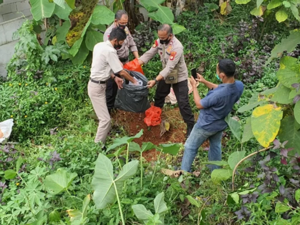 Polisi saat membongkar makam diduga babi ngepet di Depok, Rabu (28/4). (photo/dok. Istimewa)