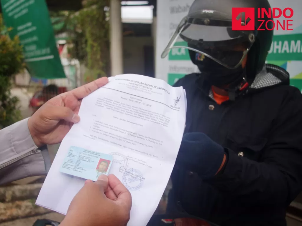 Petugas memeriksa kelengkapan Surat Izin Keluar Masuk (SIKM) Jakarta di Cek Poin PSBB Lampiri, Kalimalang, Jakarta, Selasa (26/5/2020). (INDOZONE).