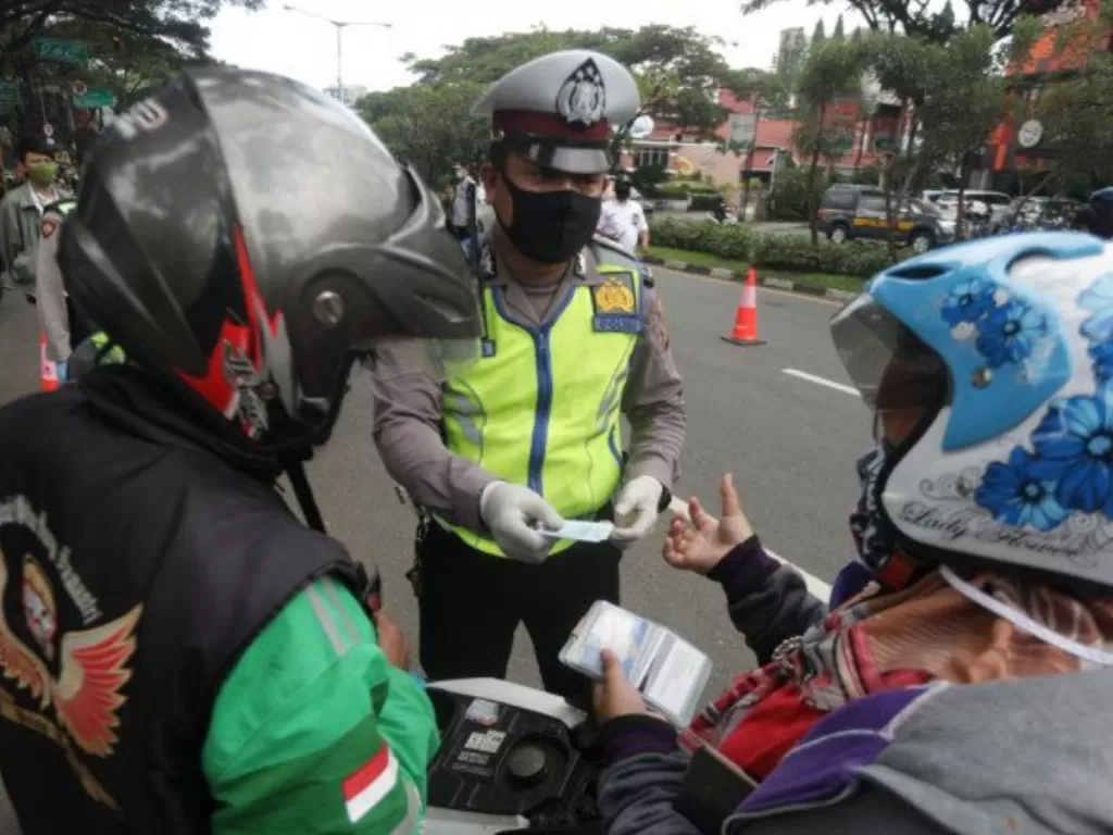 Polisi melakukan pemeriksaan pada pengguna jalan pada masa penerapan pembatasan sosial berskala besar untuk mengendalikan penularan Covid-19. (ANTARA/HO/Humas Pemkot Bandung)