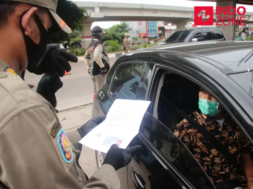 Petugas memeriksa kelengkapan Surat Izin Keluar Masuk (SIKM) Jakarta di Cek Poin PSBB Lampiri, Kalimalang, Jakarta, Selasa (26/5/2020). (INDOZONE)
