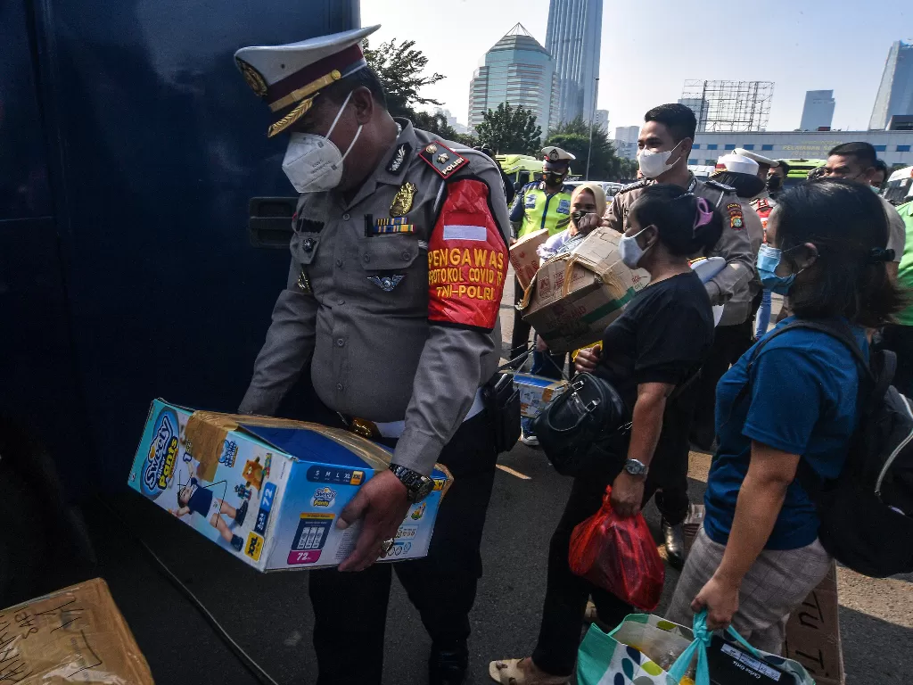 Petugas kepolisian membawa barang milik penumpang (ANTARA FOTO/Muhammad Adimaja)
