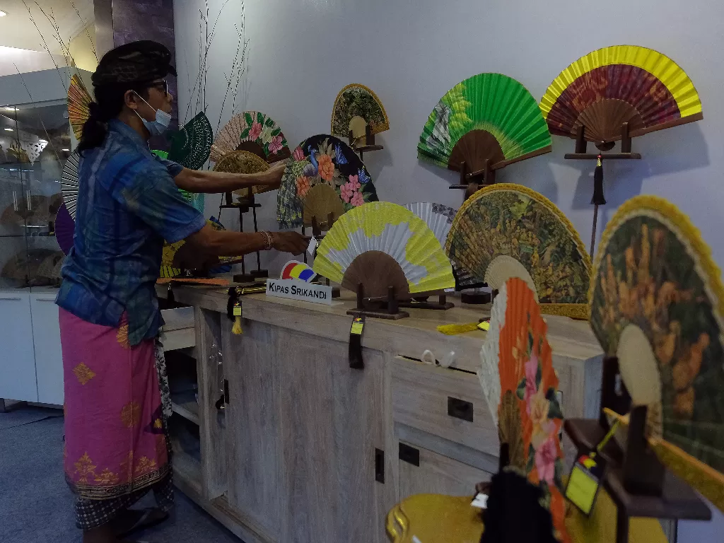 Pedagang menata sejumlah kipas yang merupakan produk kerajinan tangan (ANTARA FOTO/Nyoman Hendra Wibowo)