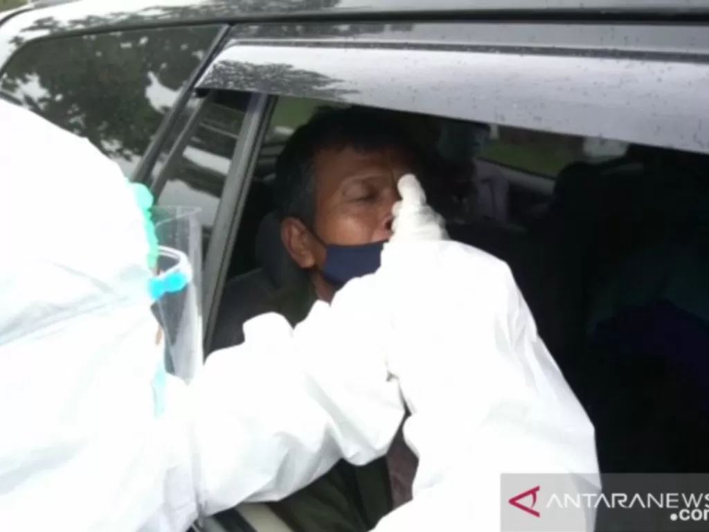Ilustrasi - Petugas sedang mengambil sampel rapid test antigen dari seorang calon penumpang saat pemeriksaan di rapid test drive thru Farmalab Bandara SMB II Palembang, Rabu (13/1/2021) (photo/ANTARA/Aziz Munajar/ilustrasi)