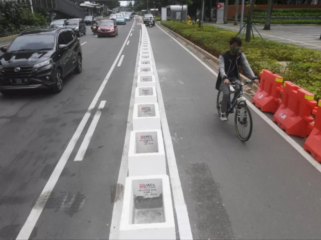 Pesepeda melintasi jalur khusus sepeda yang telah diberikan pembatas jalur permanen di Jalan Jenderal Sudirman, Jakarta. (Foto: ANTARA/Akbar Nugroho Gumay)