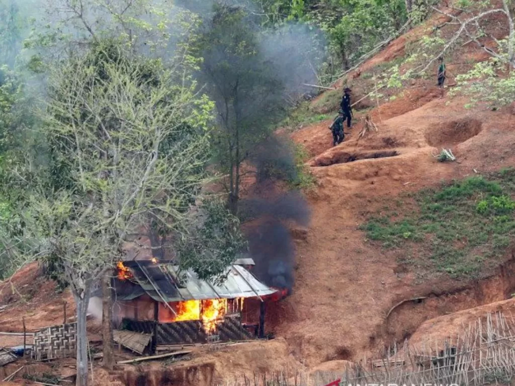 Pasukan etnis minoritas Karen terlihat setelah membakar sebuah bangunan di dalam pos militer Myanmar dekat perbatasan ThailandRabu (28/4/2021). (REUTERS/Athit Perawongmetha)