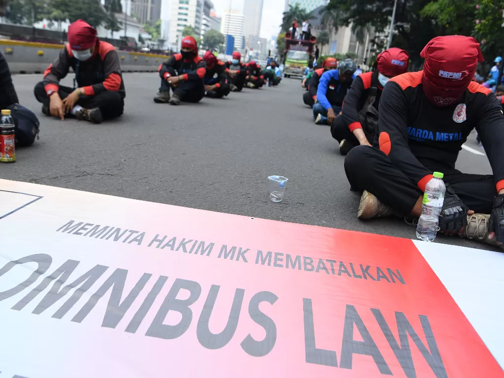 Sejumlah buruh yang tergabung dalam Konfederasi Serikat Pekerja Indonesia (KSPI) berunjuk rasa di kawasan Patung Kuda, Jakarta, Senin (12/4/2021). Dalam aksinya mereka meminta Mahkamah Konstitusi membatalkan dan mencabut UU Cipta Kerja klaster Ketenagaker