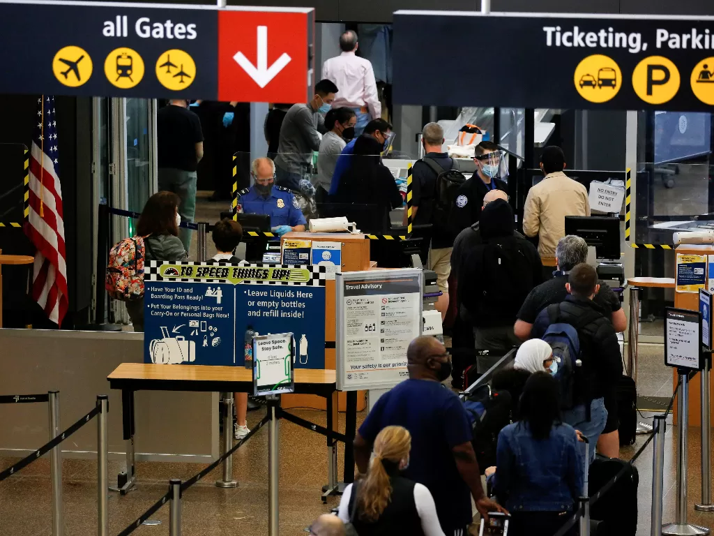 Wisatawan mengantre di jalur keamanan yang terbatas pada setiap jalur lain untuk jarak sosial di Bandara Internasional Seattle-Tacoma di SeaTac, Washington, AS 12 April 2021. (photo/REUTERS/Lindsey Wasson)