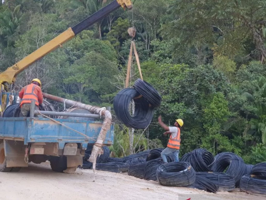 Pemasangan tiang listrik untuk jaringan menuju Krayan, Nunukan yang menempuh medan berat. (Dok. Humas PLN Kalimantan Utara)