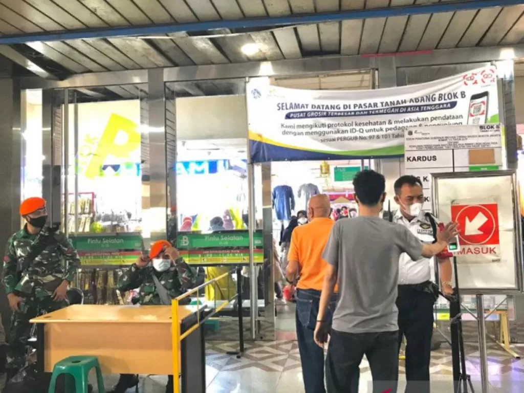 Petugas gabungan termasuk prajurit TNI tengah berjaga di pintu masuk Pasar Tanah Abang dan di sana ditempatkan alat monitor suhu tubuh, Senin (3/5/2021) (ANTARA/Anisyah Rahmawati.)