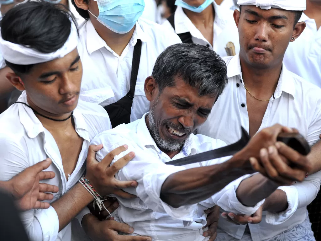 Seorang umat Hindu yang kesurupan menusukkan keris ke tubuhnya (ANTARA FOTO/Fikri Yusuf)