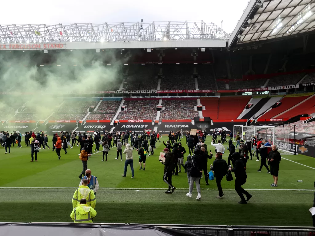Para fans MU menerobos stadion Old Trafford. (photo/REUTERS/Carl Recine)