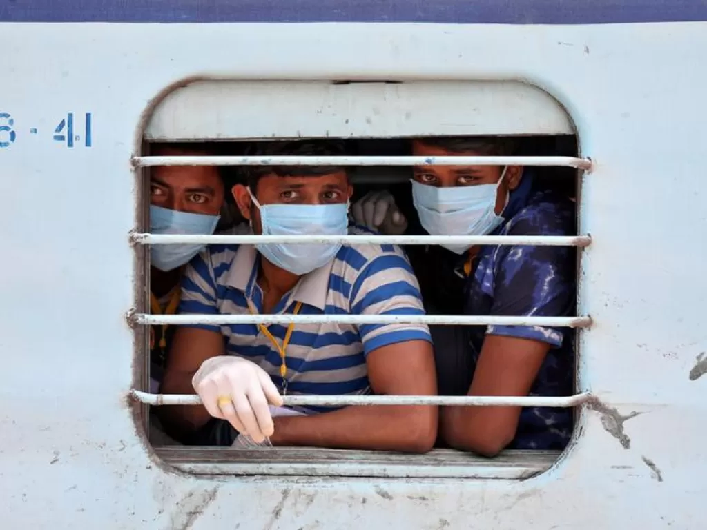 Pekerja migran berada di dalam kereta mengenakan masker di Bengal Barat, Kolkata, India, Selasa (5/5/2020). (REUTERS/Rupak De Chowdhuri)