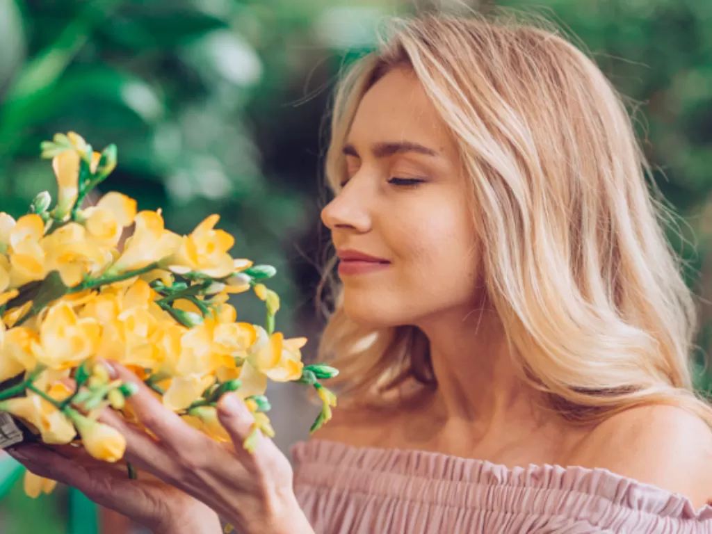 Ilustrasi wanita mencium aroma bunga. (Freepik)