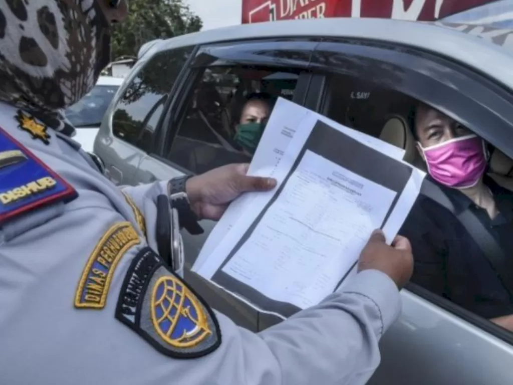 Petugas gabungan memeriksa pengendara yang akan masuk ke wilayah DKI Jakarta. (ANTARA FOTO/Muhammad Adimaja)