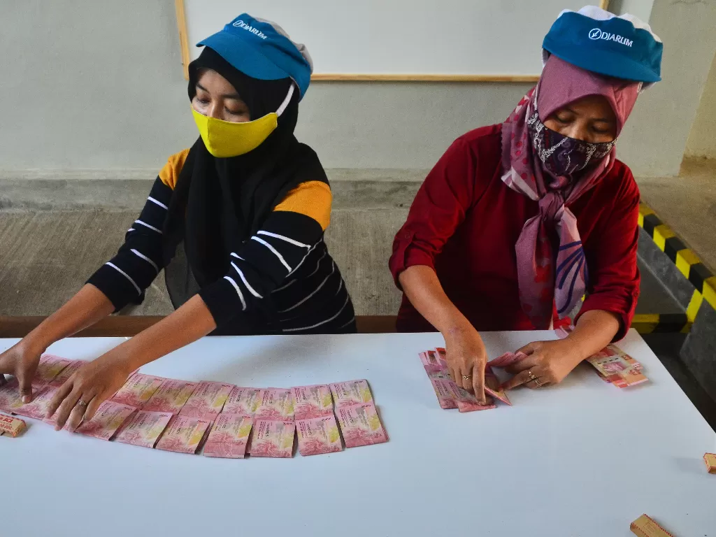 Ilustrasi - Pekerja menghitung uang Tunjangan Hari Raya (THR) yang diterimanya di pabrik rokok PT Djarum, Kudus, Jawa Tengah, Kamis (29/4/2021). (ANTARA/Yusuf Nugroho)