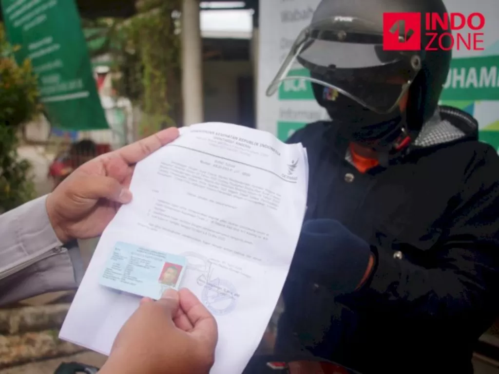 Petugas memeriksa kelengkapan Surat Izin Keluar Masuk (SIKM) Jakarta di Cek Poin PSBB Lampiri, Kalimalang, Jakarta. (INDOZONE).