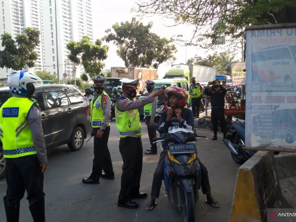  Petugas gabungan memeriksa pengendara yang melintas di Jalan Daan Mogot, Kalideres, Jakarta Barat, pada masa larangan mudik, Jumat (7/5/2021). (photo/ANTARA/Dewa Ketut Sudiarta Wiguna)