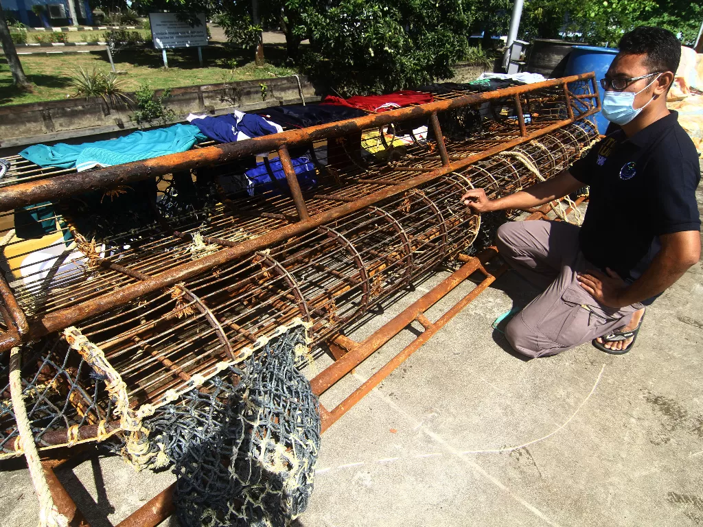 Seorang petugas memperlihatkan barang bukti berupa alat penangkap teripang milik kapal ikan asing berbendera Vietnam (ANTARA FOTO/Jessica Helena Wuysang)