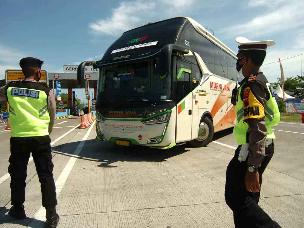 Personel kepolisian memutar balik bus yang keluar di pintu tol Pejagan, Brebes, Jawa Tengah, Minggu (9/5/2021). (ANTARA/Oky Lukmansyah)