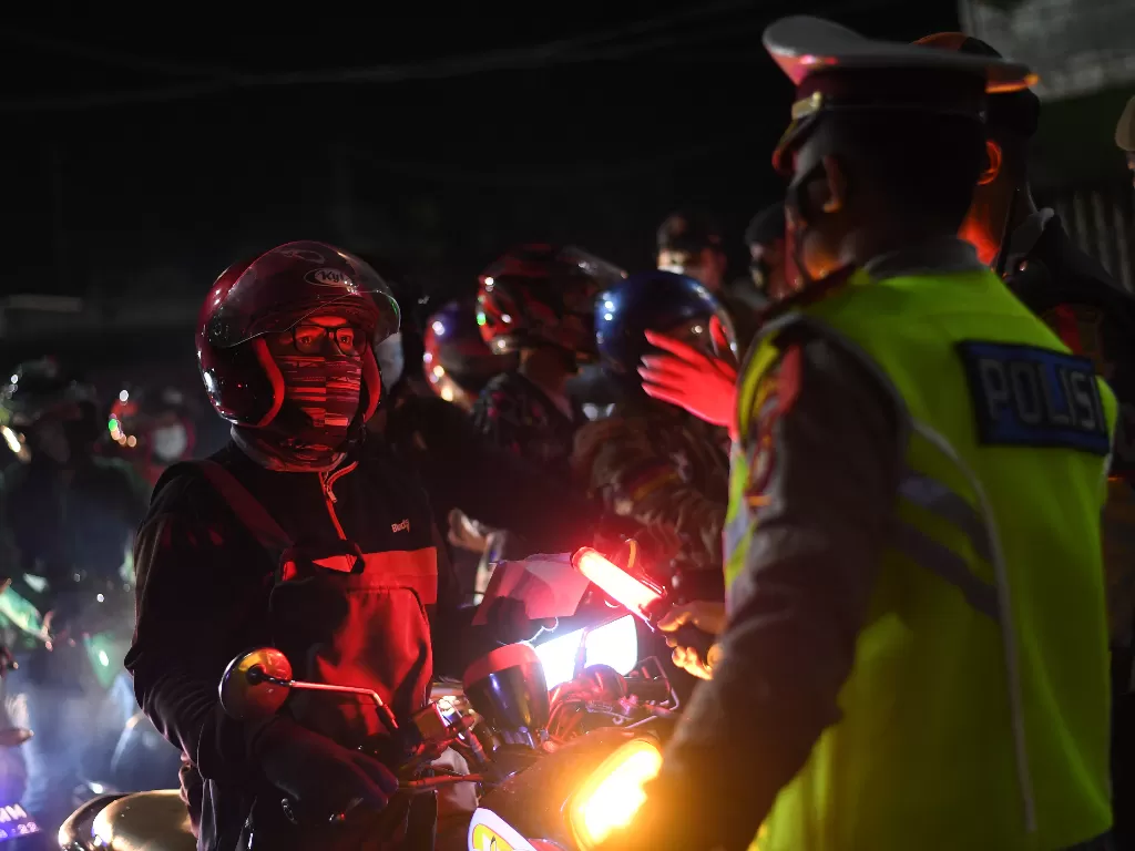  Petugas kepolisian menghentikan kendaraan saat melintasi posko penyekatan mudik di Kedungwaringin, Kabupaten Bekasi, Jawa Barat, Senin (10/5/2021). (photo/ANTARA FOTO/Wahyu Putro A)