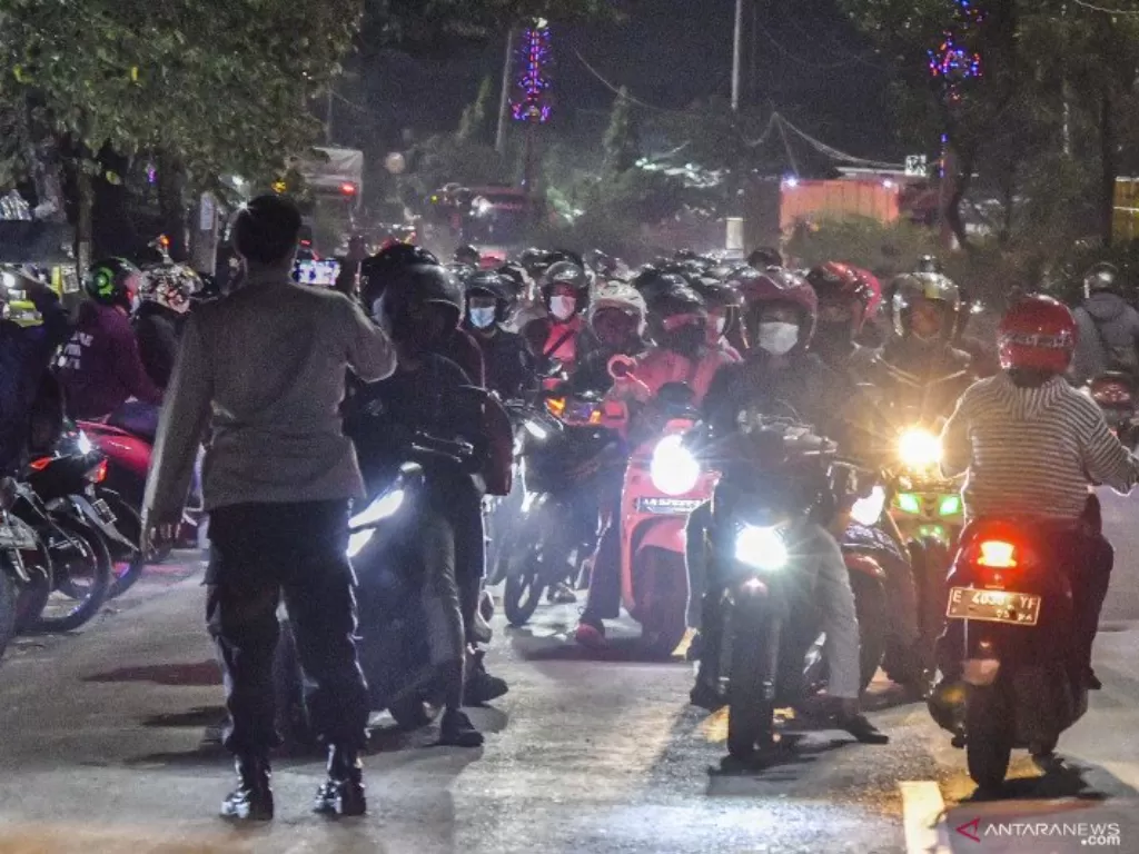 Petugas Kepolisian menghalau sejumlah pemudik motor yang melawan arah untuk menghindari posko penyekatan mudik di Kedungwaringin, Kabupaten Bekasi, Jawa Barat, Minggu (9/5/2021). (photo/ANTARA FOTO/ Fakhri Hermansyah)