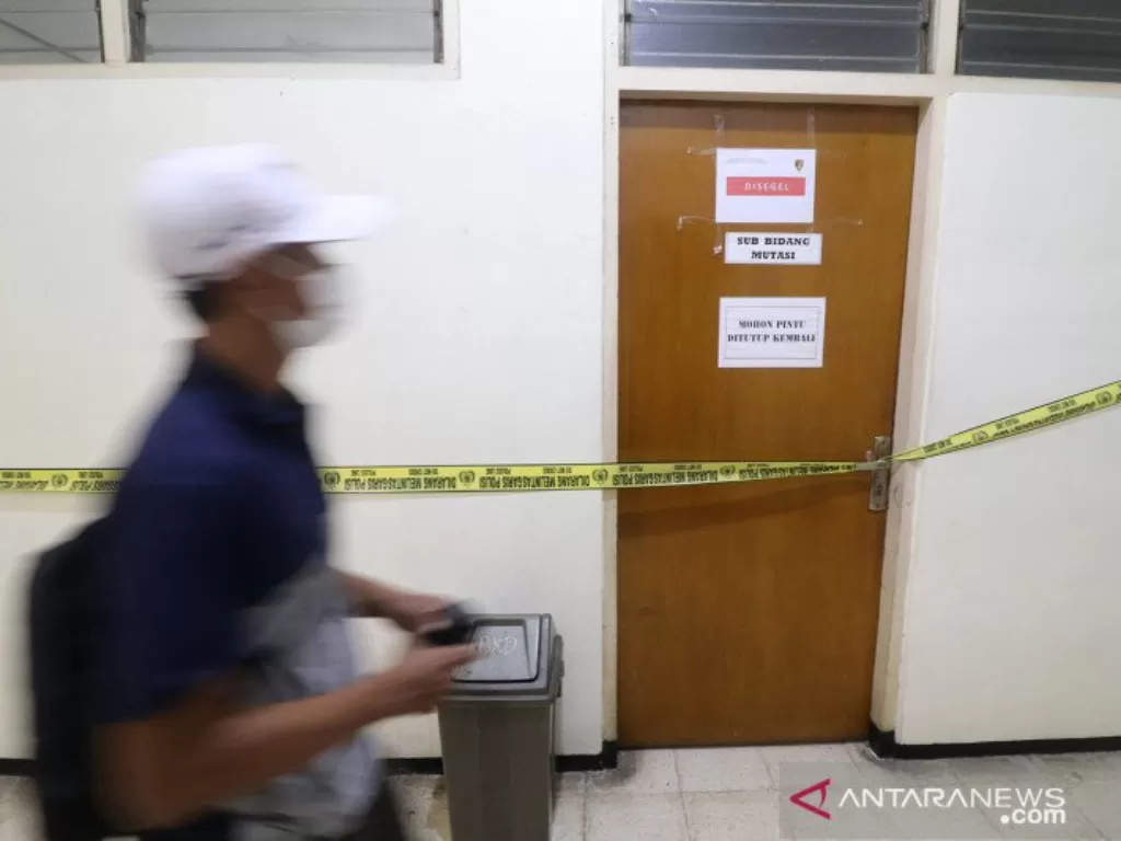 Seorang pria melintas di depan ruangan yang disegel Komisi Pemberantasan Korupsi (KPK) di gedung Badan Kepegawaian Daerah (BKD) Nganjuk, Jawa Timur, Senin (10/5/2021). (ANTARA FOTO/Prasetia Fauzani/rwa.)