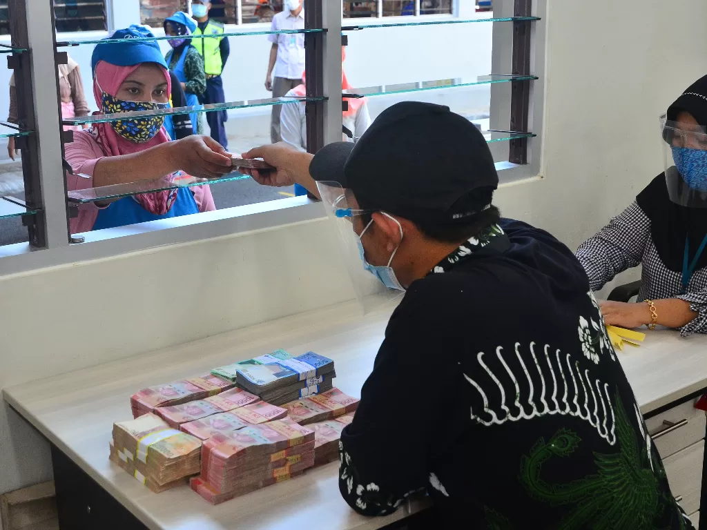 ekerja menerima uang Tunjangan Hari Raya (THR) yang diterimanya di pabrik rokok PT Djarum, Kudus, Jawa Tengah, Kamis (29/4/2021). (ANTARA FOTO/Yusuf Nugroho).