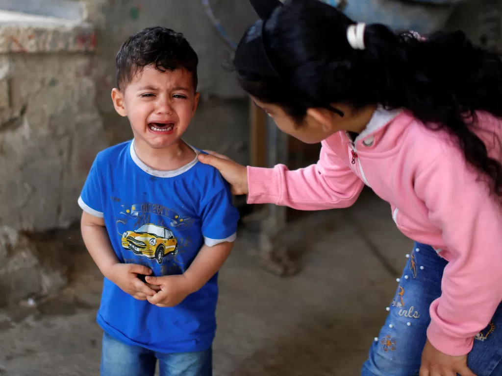 Seorang bocah Palestina menangis setelah serangan Israel menewaskan saudaranya (REUTERS/Mohammed Salem)