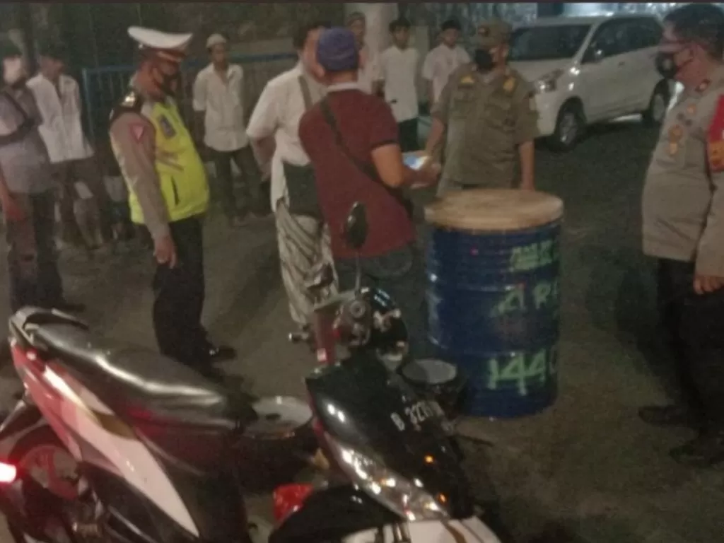 Personel Polres Metro Jakarta Timur menghentikan upaya takbir keliling oleh masyarakat di Jalan Raya Pasar Rebo kilometer 28, Rabu (12/5/2021) malam sekitar pukul 22.20 WIB. Polisi meminta masyarakat itu kembali ke rumah masing-masing dan memberikan merek