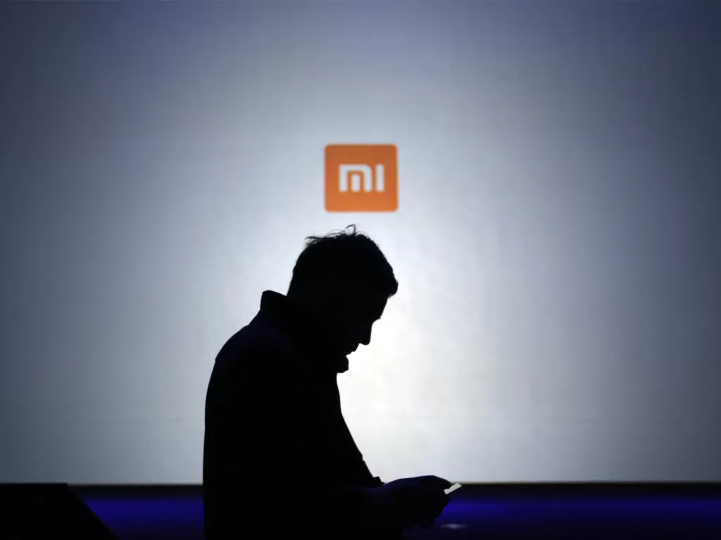 Ilustrasi seorang pria sedang berada di delam logo Xiaomi (photo/REUTERS/Jason Lee)