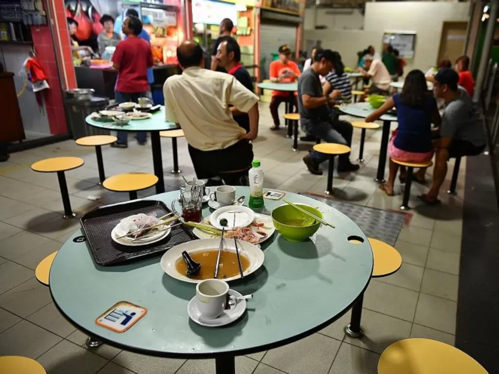 Piring dan alat makan bekas ditinggalkan pelanggan di sentra jajanan di Blok 210, Singapura. (Photo/The Strait Times)