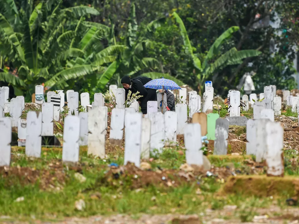 Warga berdoa di makam keluarganya saat melakukan ziarah kubur di pemakaman khusus COVID-19 di TPU Srengseng Sawah, Jakarta, Kamis (13/5/2020).  (photo/ANTARA FOTO/Galih Pradipta)