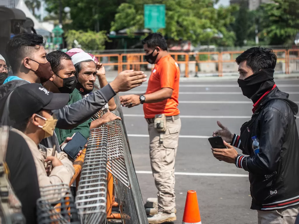 Petugas memberikan imbauan kepada warga yang akan berwisata untuk kembali pulang (ANTARA FOTO/Aprillio Akbar)