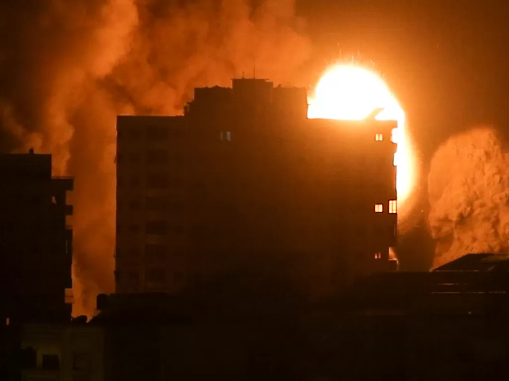 Asap dan api membumbung di atas gedung selama serangan udara Israel, di tengah maraknya kekerasan Israel-Palestina, di Kota Gaza 17 Mei 2021. (photo/REUTERS/Ibraheem Abu Mustafa)