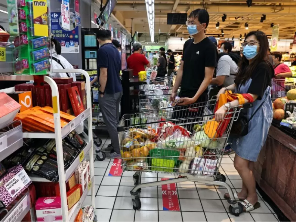 Orang-orang menunggu untuk membayar belanjaan mereka setelah pemerintah menyarankan orang untuk mengurangi meninggalkan rumah mereka dan membatasi pertemuan karena meningkatnya jumlah infeksi COVID-19 yang ditularkan secara lokal, di Taipei, Taiwan, 15 Me