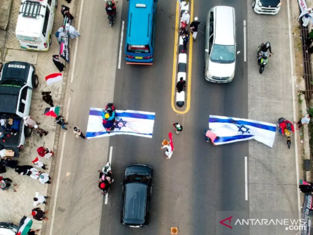 Lembaga Kemanusiaan, Asar Humanity menggelar aksi bela Palestina dengan cara mengibarkan bendera Palestina dan menaruh dua bendera Israel berukuran raksasa di tengah jalan raya Parung, Kabupaten Bogor, Jawa Barat. (ANTA/HO-Roozika Sunandila)