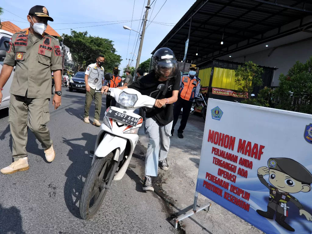 Petugas menghentikan pengendara yang tidak mengenakan masker (ANTARA FOTO/Fikri Yusuf)