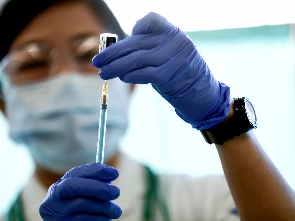 Pekerja medis di Jepang tengah mengisi jarum suntik dengan vaksin (Behrouz Mehri/Pool via REUTERS/File Photo)