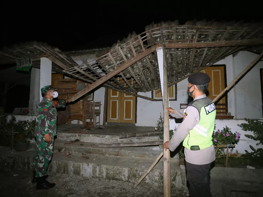 Personel TNI dan Polri mengecek kondisi rumah warga yang rusak pascagempa di Desa Ploso Kecamatan Selopuro, Blitar, Jawa Timur, Jumat (21/5/2021). (ANTARA FOTO/Irfan Anshori)