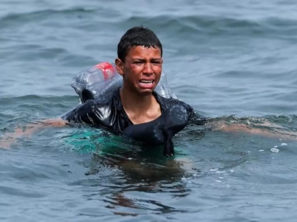 Bocah ini menangis setelah berenang dari Maroko ke Spanyol. (Photo/Reuters)