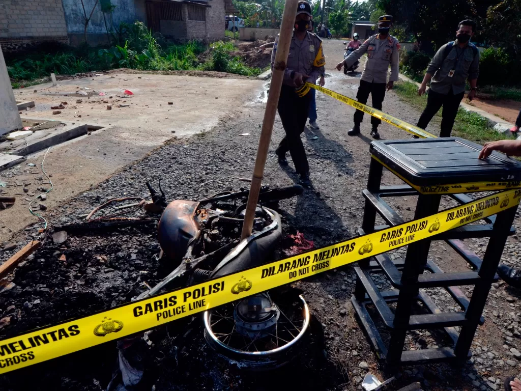 Petugas memasang garis polisi di puing kendaraan dinas yang di bakar oleh massa di Mapolsek Candipuro, Lampung Selatan, Lampung, Rabu (19/5/2021). (ANTARA FOTO/Ardiansyah)