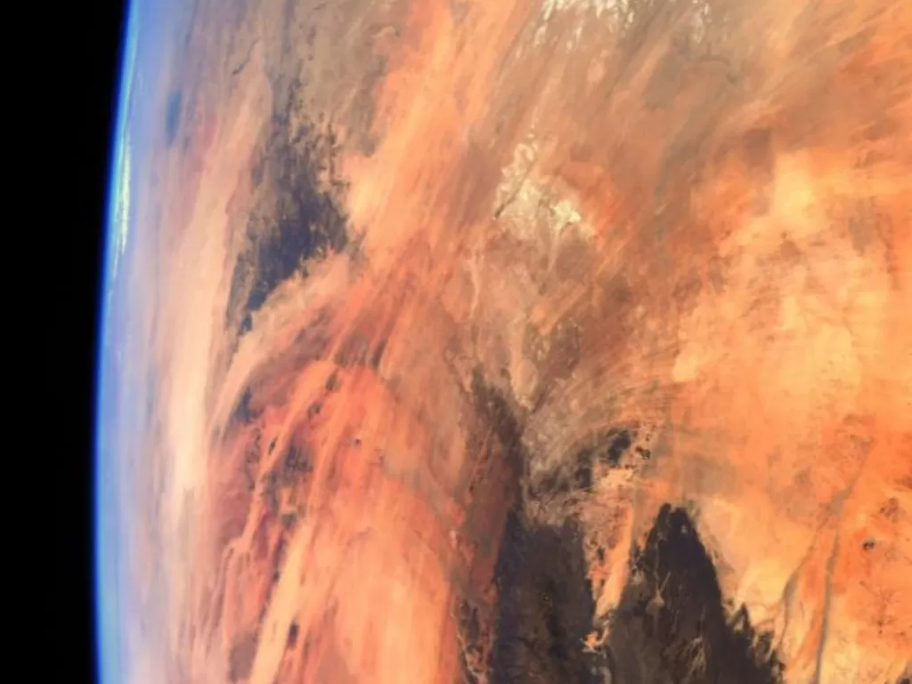 Tampilan foto Bumi yang memerah. (photo/Dok.ESA/NASA–T. Pesquet)