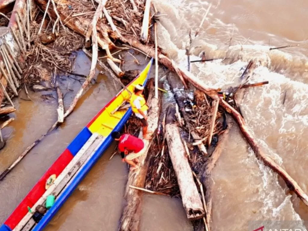  Tim pencari dibantu warga saat menyelusuri Sungai Kayan yang arus deras dan banyak batang pohon, kemarin. (Iskandar Zulkarnaen/Antara) 