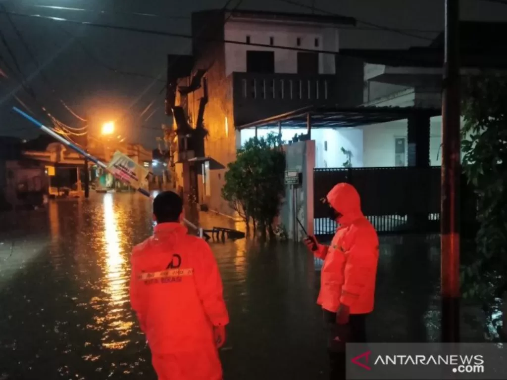 Petugas BPBD Kota Bekasi, Jawa Barat melakukan pemantauan di titik banjir yang melanda wilayah itu pada Sabtu (29/5) petang. (photo/ANTARA/Pradita Kurniawan Syah)