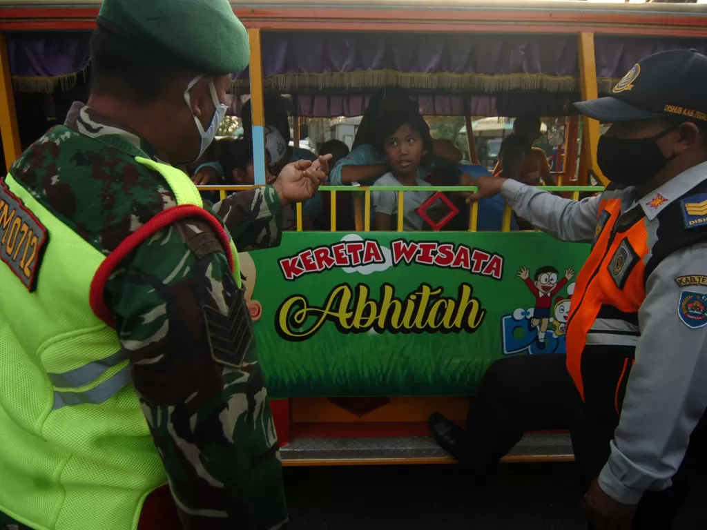 Personel TNI dan Dinas Perhubungan berbincang dengan penumpang odong-odong yang tidak memakai masker (ANTARA FOTO/Oky Lukmansyah)