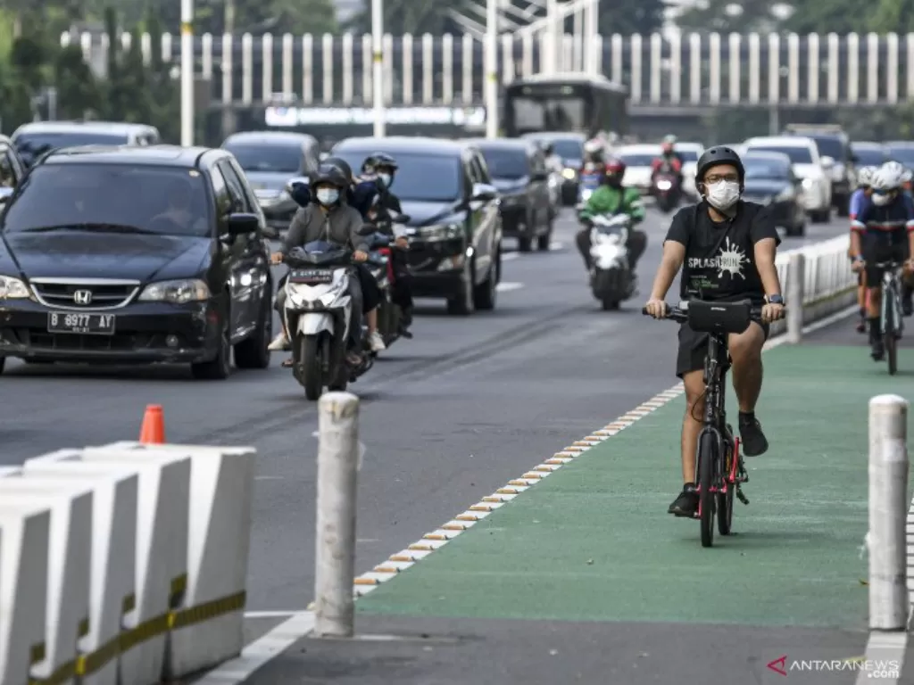 Pesepeda memacu kecepatannya di jalur sepeda permanen di Jalan Jenderal Sudirman, Jakarta, Minggu (9/5/2021). (ANTARA/M Risyal Hidayat)