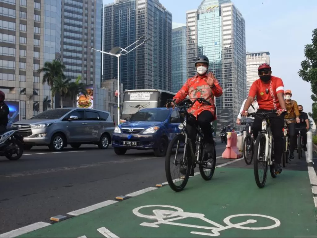  Gubernur DKI Jakarta Anies Baswedan (kiri) bersepeda saat berangkat kerja menuju kantornya di Jakarta, Kamis (3/6/2021). (ANTARA FOTO/Indrianto Eko Suwarso)