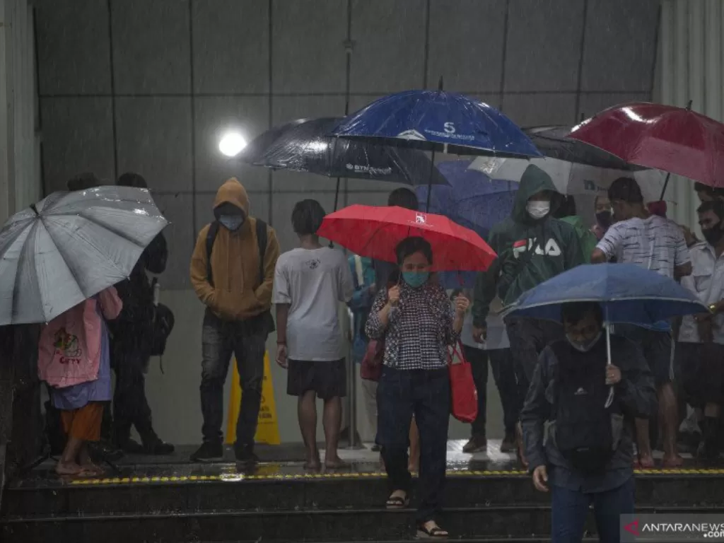 Warga menggunakan payung saat hujan mengguyur Stasiun MRT Dukuh Atas BNI, Jakarta, Kamis (13/8/2020). (ANTARA FOTO/Aditya Pradana Putra/aww.)