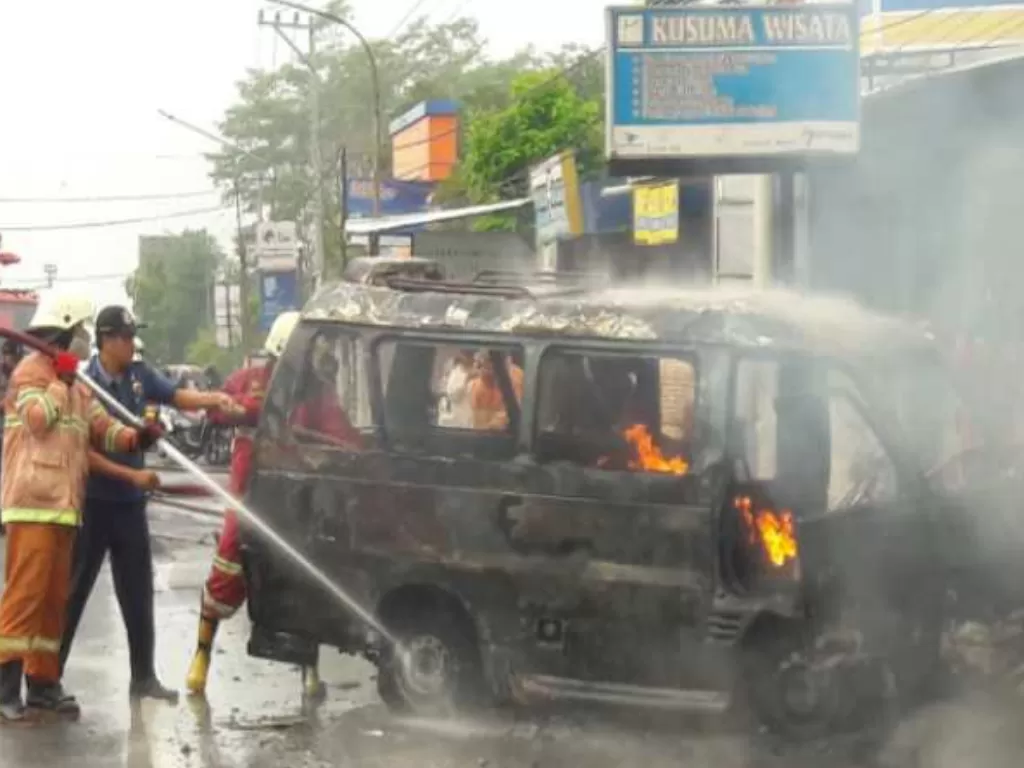 Petugas pemadam kebakaran berupaya memadamkan kobaran api yang membakar sebuah angkutan di Kowangan, Kabupaten Temanggung. (ANTARA/Heru Suyitno)