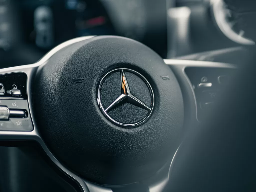 Tampilan logo Mercedes-Benz di salah satu mobil buatannya (Ilustrasi/Unsplash/Albert Vincent Wu)